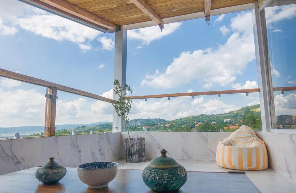 un grupo de jarrones sentados en una mesa frente a una ventana en Irina en Soko Banja