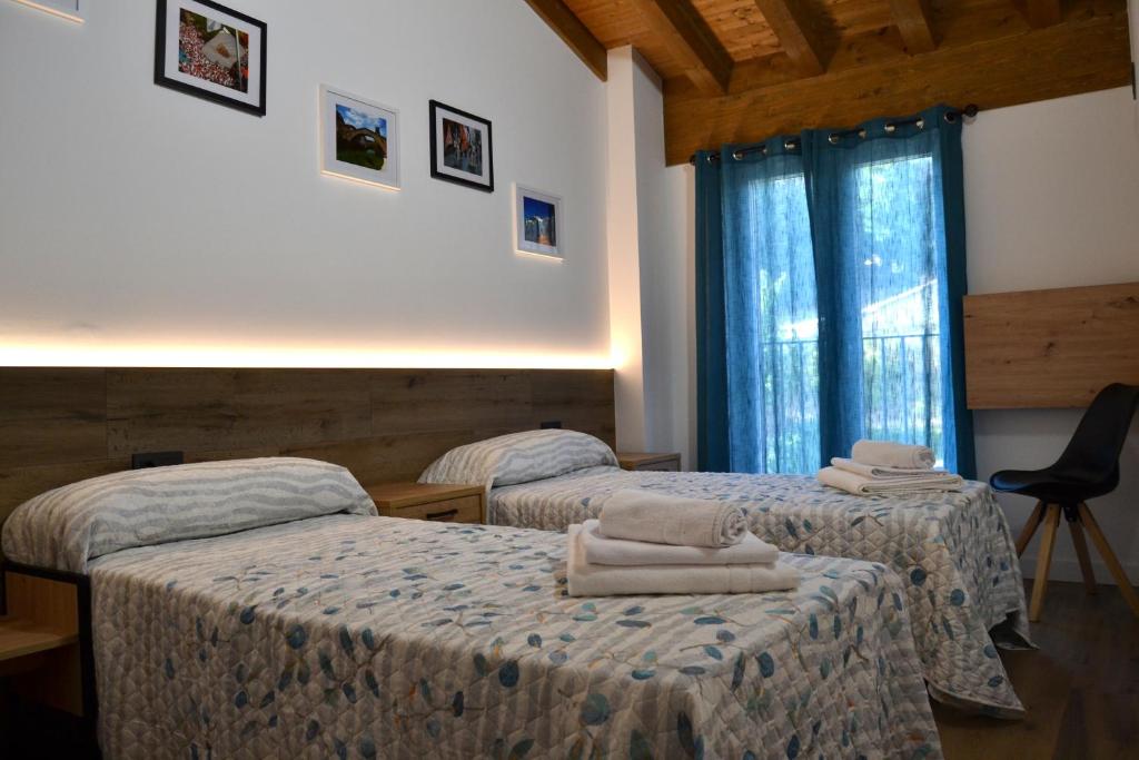 a hotel room with two beds and a window at Apartamento El Mirador de la Rua in Estella