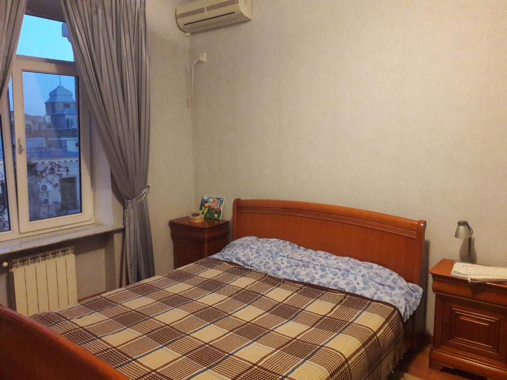 een slaapkamer met een bed en een raam bij NIZAMI Street 1 Bedroom in Baku