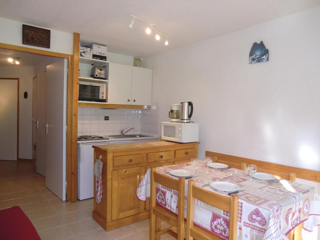 a kitchen with a table with chairs and a microwave at Appartement La Plagne Montalbert , 2 pièces, 5 personnes - FR-1-181-2463 in Aime-La Plagne