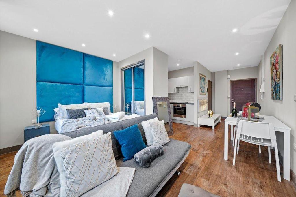 ein Wohnzimmer mit einem Sofa und einem Bett in der Unterkunft Marble DELUXE - City Centre Apt- Parking & Wifi in Maidstone