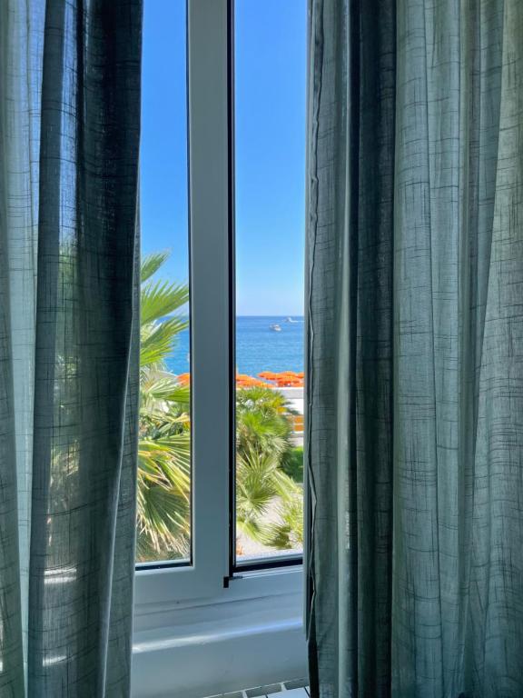 a window with a view of the beach and the ocean at Maniman in Varazze