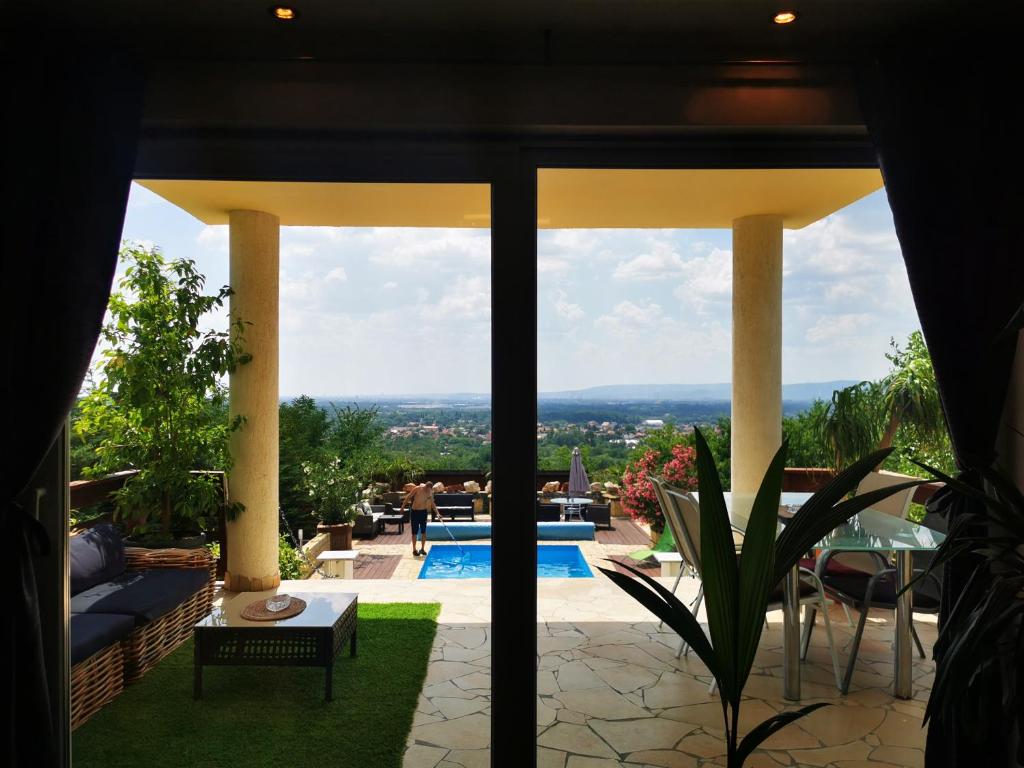 FótにあるVilla Somlyóのプール付きの家のパティオからの景色を望めます。