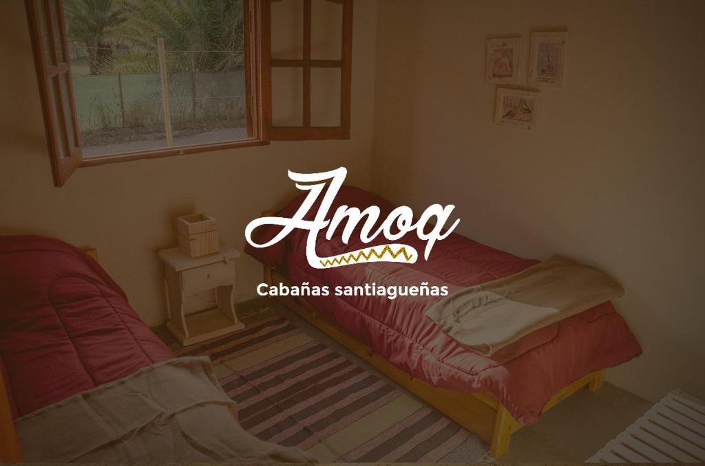 サンティアゴ・デル・エステロにあるAmoqのオメガの看板が付いたベッドが備わる客室です。