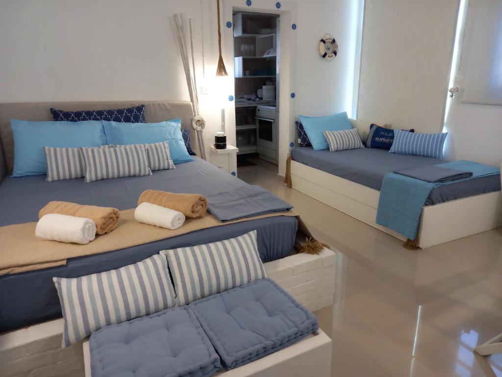 twee bedden in een kamer met blauw en wit bij Luxury loving home in Tolo