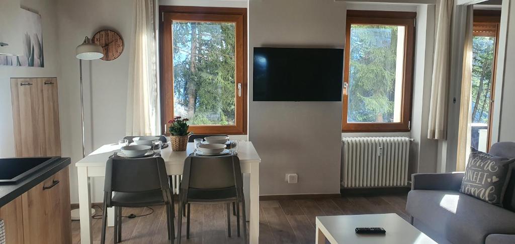 a kitchen and living room with a table and chairs at Moda Apartments 01 in Sestriere