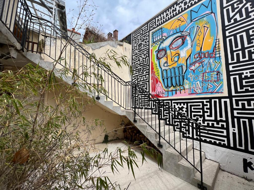 un escalier avec une fresque murale sur le côté du bâtiment dans l'établissement Pépite au plein centre historique, à Lons-le-Saunier