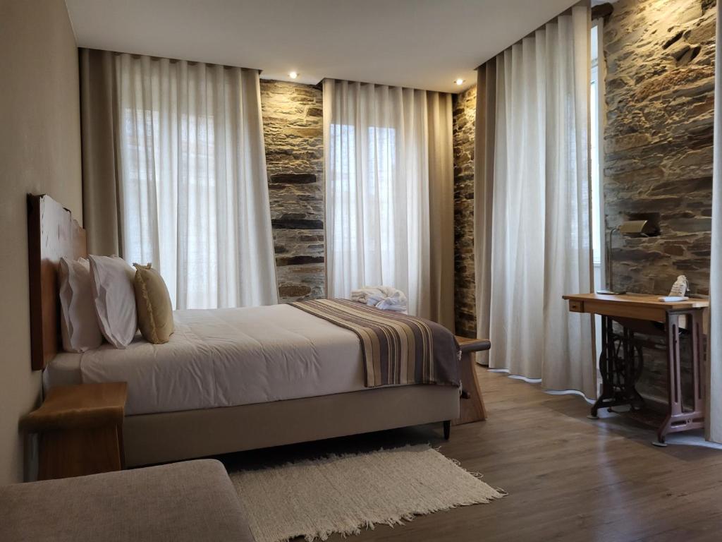 1 dormitorio con cama, escritorio y ventana en Villa Alva Guest House, en Coja
