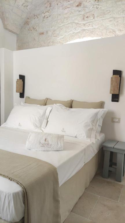 1 dormitorio con 1 cama grande con sábanas blancas en Nobile Dimora di Puglia, en Ostuni
