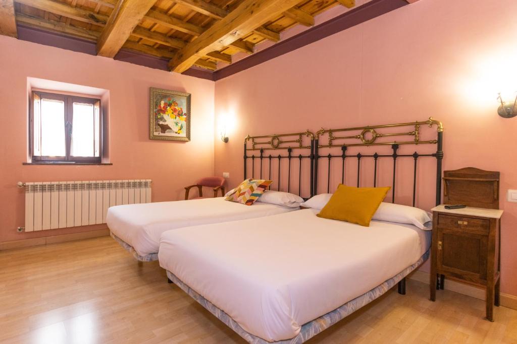 a bedroom with two beds and a window at Hotel Rural Fuente del Val in Prádanos de Ojeda