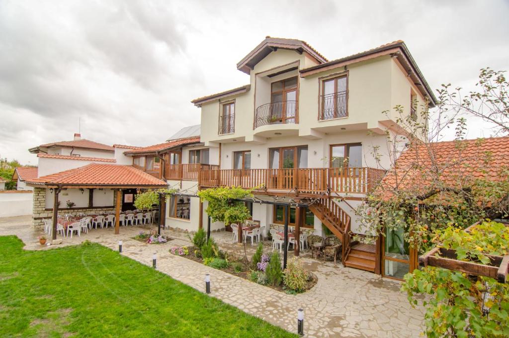 Guest House Villa Elma في Nevsha: اطلالة خارجية على منزل مع فناء
