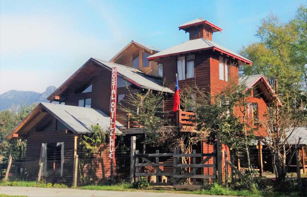a large wooden house with a tower on top of it at Hostal Quillelhue in Pucón