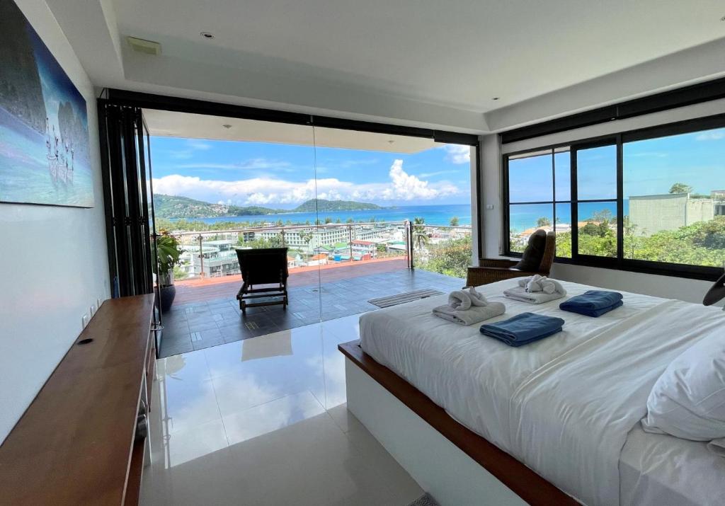 a bedroom with a bed with a view of the ocean at Andaman Hills - panoramic sea view house in Patong in Patong Beach