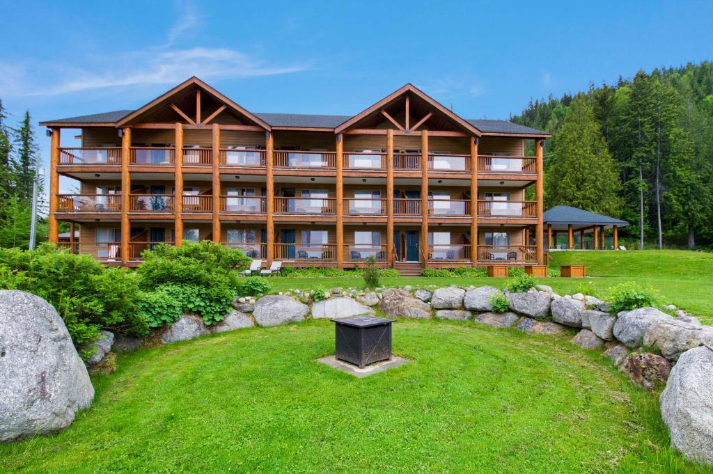 a large log building with a lawn in front of it at Kootenay Lakeview Resort BW Signature Collection in Balfour