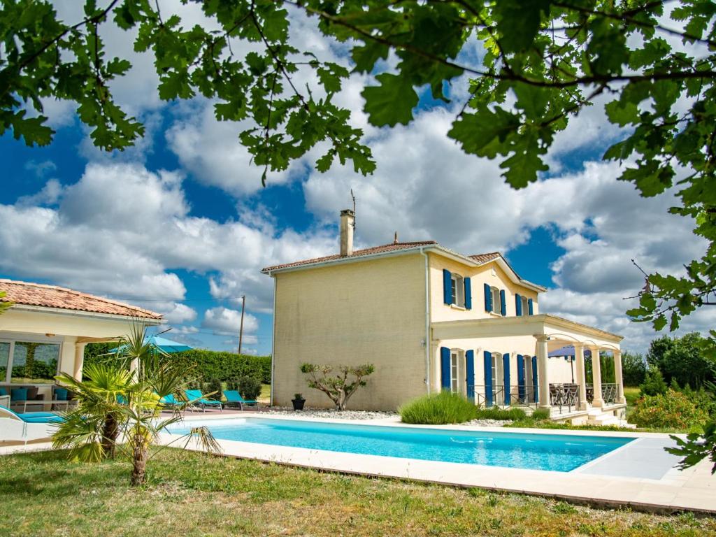 una villa con piscina frente a una casa en Villa de Montaigu, en Montaigu-de-Quercy