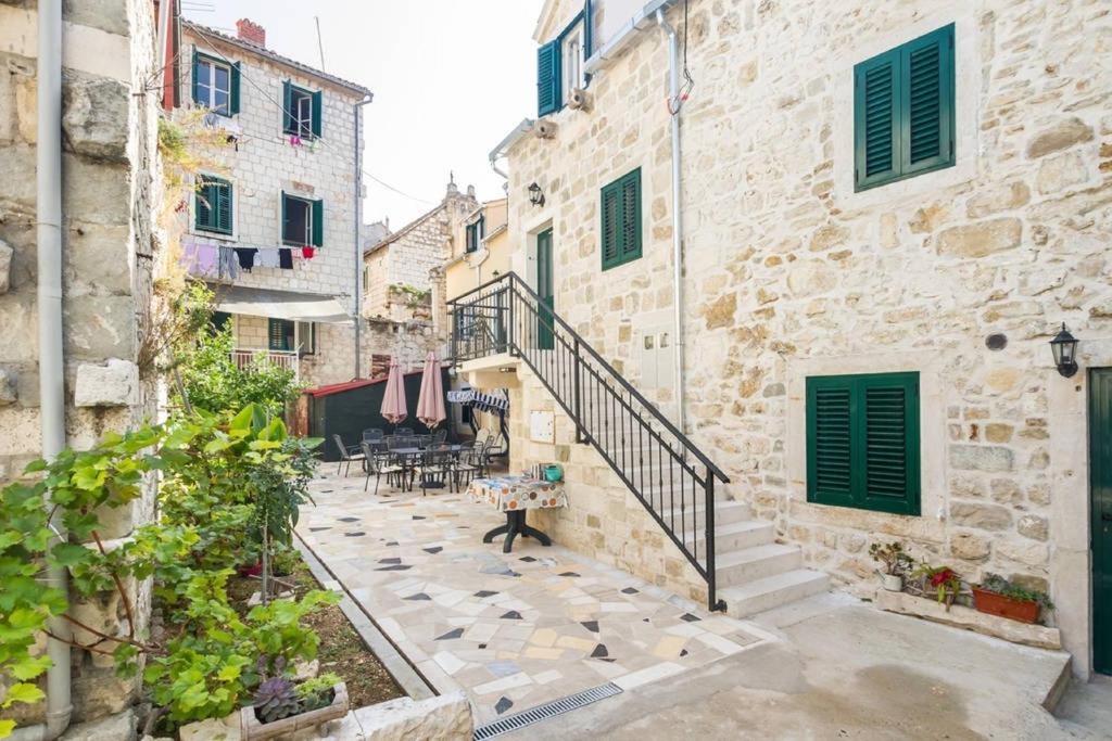 um beco de pedra com escadas, uma mesa e cadeiras em Peruzovic Rooms 1 em Split