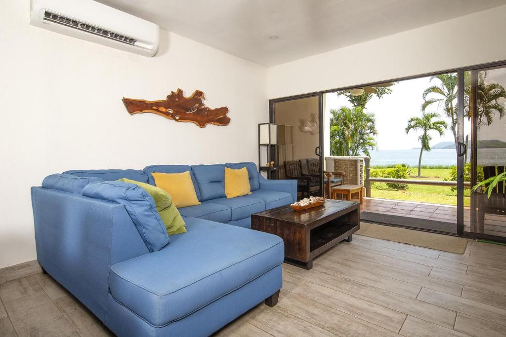 sala de estar con sofá azul y mesa en Newly Remodeled Ground-Floor Unit in Flamingo in Front of Beach, en Playa Flamingo