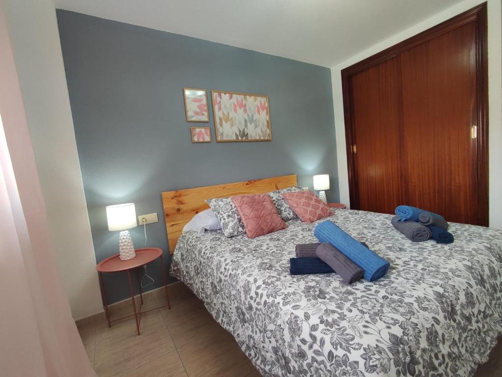 una camera da letto con un letto con una sedia blu e due lampade di Sweet Lola a El Médano