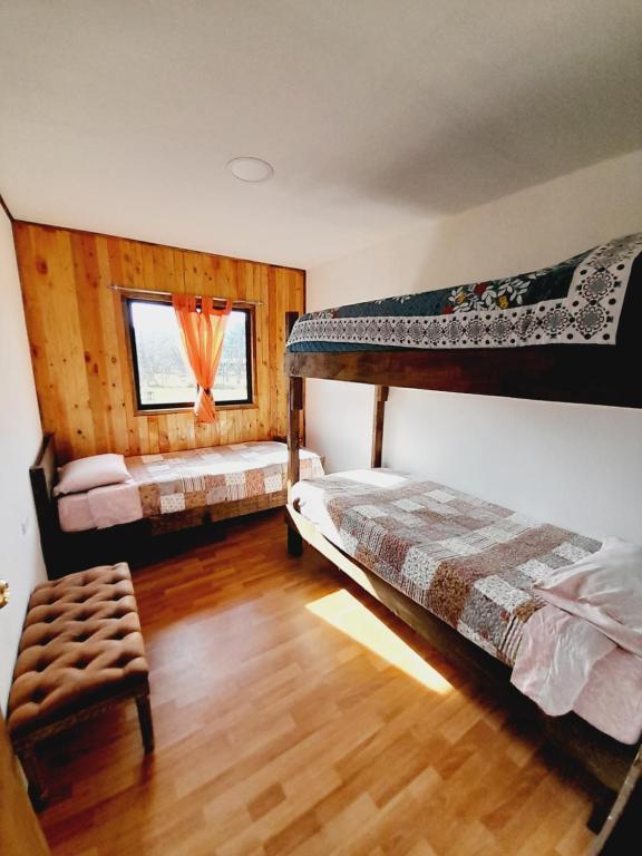 a bedroom with two bunk beds and a chair at Cabanas Chosco Alto in Pucón