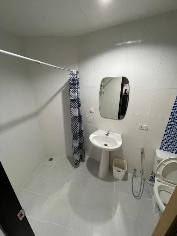 a bathroom with a sink and a toilet and a mirror at Rawai Beachside Hotel in Rawai Beach