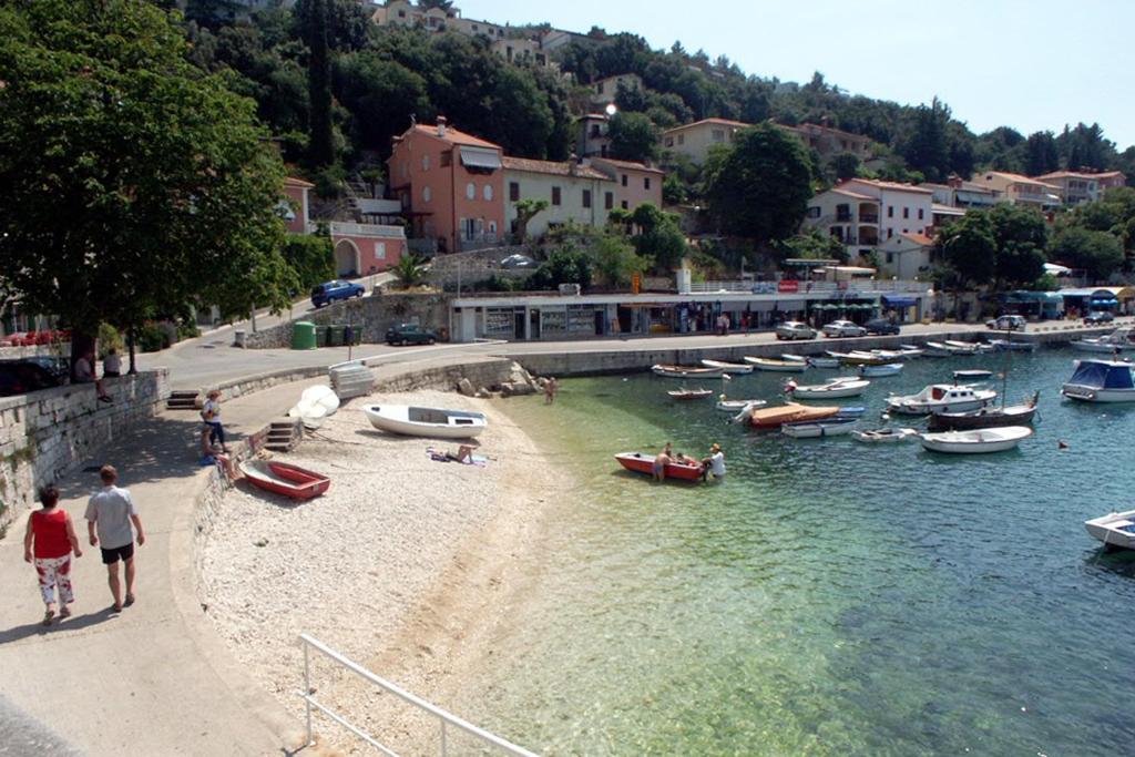 a group of boats on a beach in a body of water at Apartments with a parking space Rabac, Labin - 7441 in Rabac