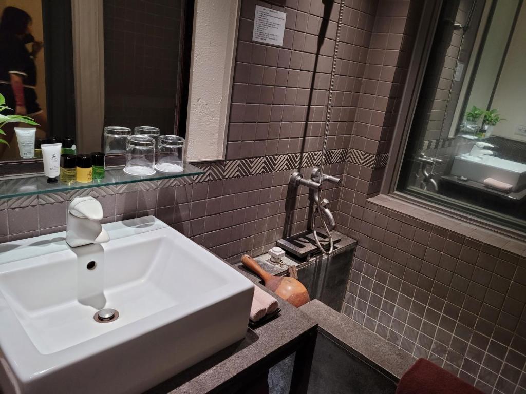 a bathroom with a white sink and a mirror at CHECK inn Select Taipei Yamgmingshan in Taipei