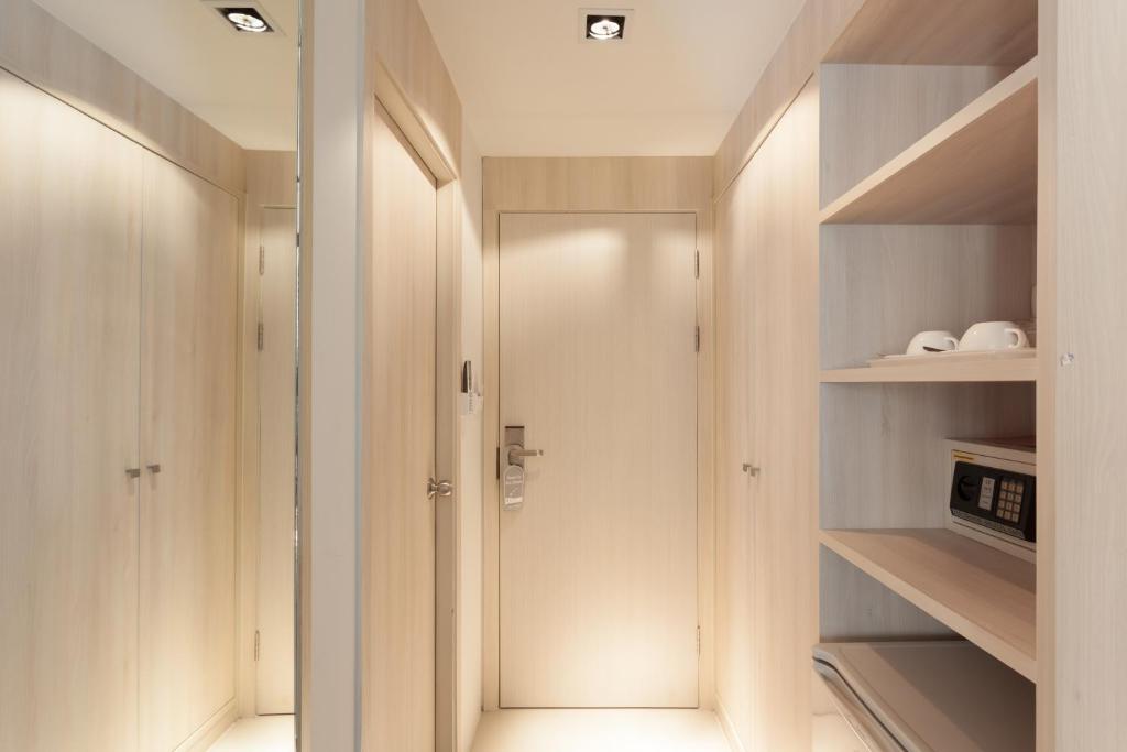 a walk in closet with wooden shelves and a door at Coral Inn in Karon Beach