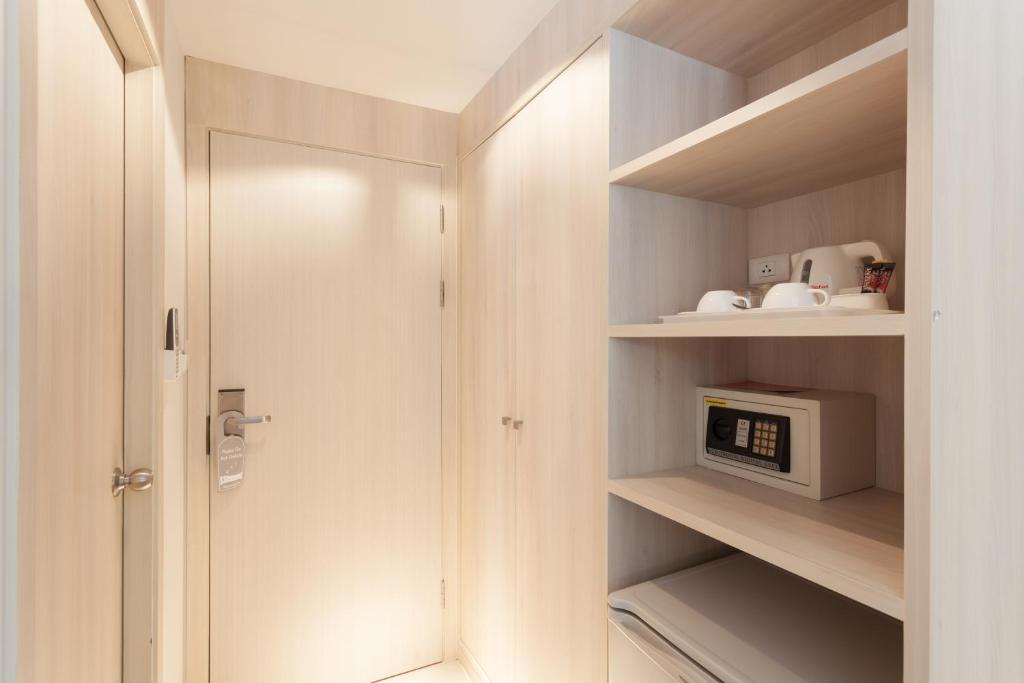 a small kitchen with a microwave in a closet at Coral Inn in Karon Beach