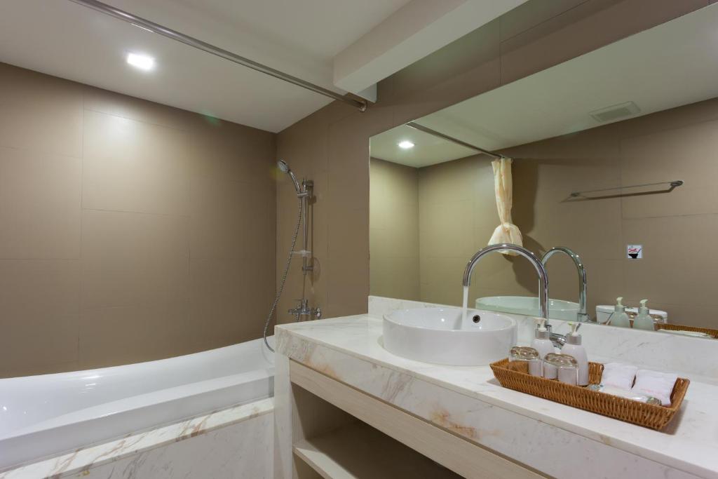 a bathroom with a sink and a tub at Coral Inn in Karon Beach