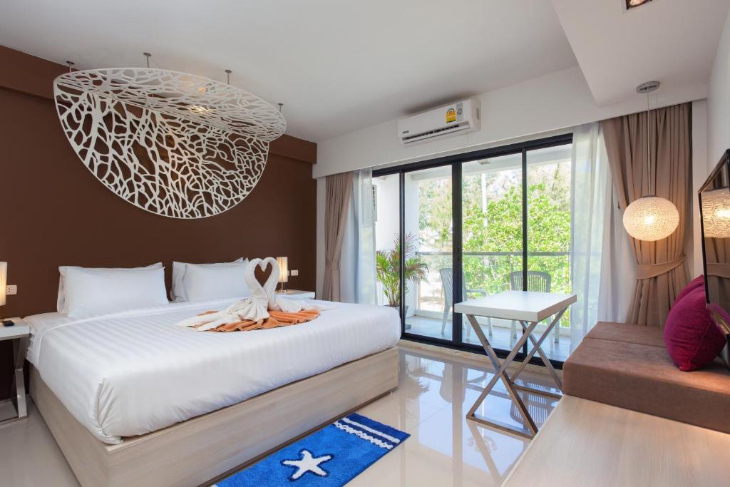 a bedroom with a bed and a chandelier at Coral Inn in Karon Beach