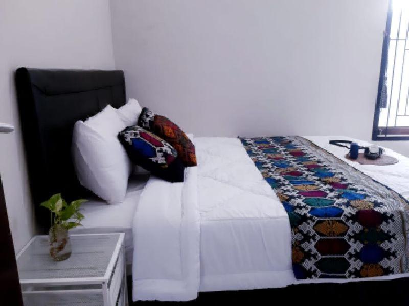 ein Schlafzimmer mit einem Bett mit Kissen darauf in der Unterkunft Laluna Guesthouse in Ampenan