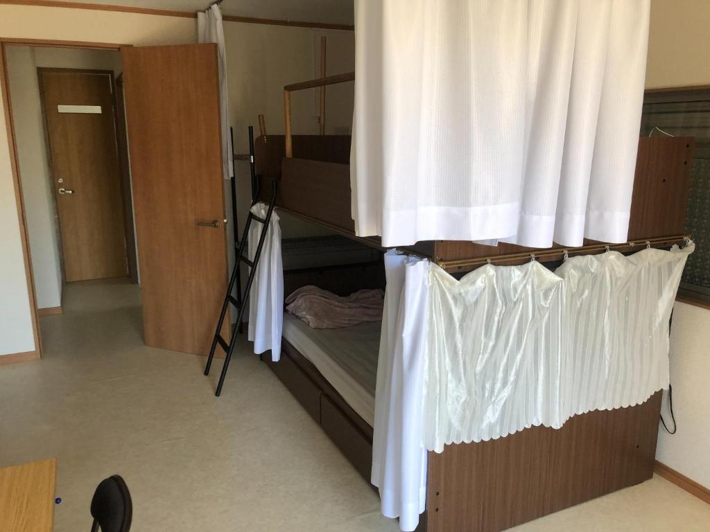 a bedroom with a bunk bed with a curtain at Kounotori no Sato no Yado - Vacation STAY 12510 in Kōnosu