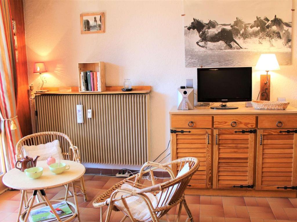 sala de estar con TV, mesa y sillas en Appartement Vars, 1 pièce, 4 personnes - FR-1-330B-195, en Vars