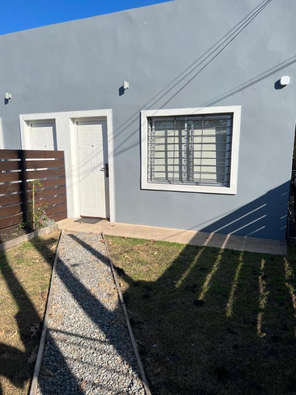 a white house with a window and a fence at Apart del Este 2 in Paysandú