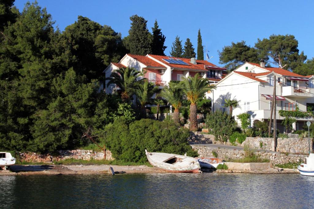 a boat sitting on the shore of a body of water at Apartments and rooms by the sea Vrboska (Hvar) - 540 in Vrboska