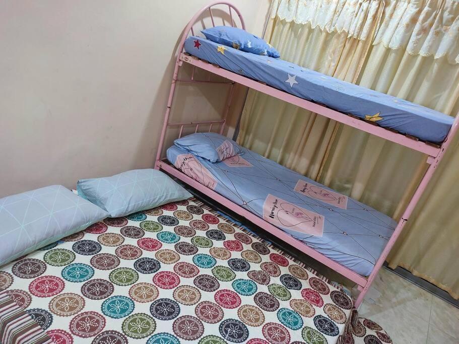 two bunk beds in a room with a floor at Mai KKB Homestay in Kuala Kubu Bharu Taman Juta in Kuala Kubu Bharu