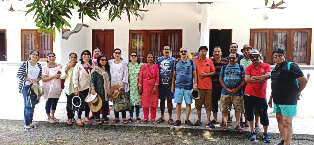 a group of people posing for a picture in front of a house at Hotel Neptune Kovalam in Trivandrum