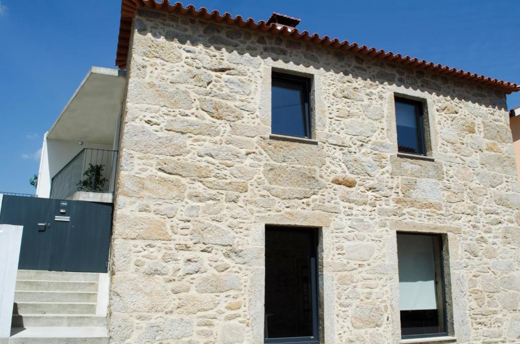 ein Steinhaus mit schwarzen Türen und Fenstern in der Unterkunft Sabor@Arte in Couto de Esteves