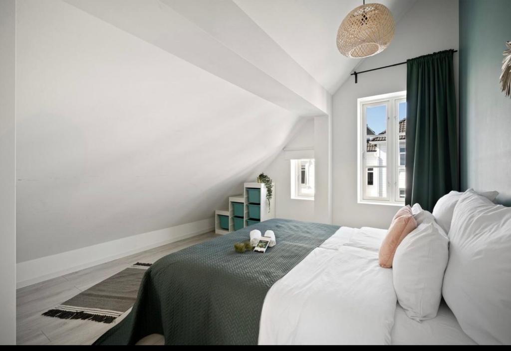 a bedroom with a bed with white sheets and a window at A Place To Stay Stavanger, apartment 3 in Stavanger