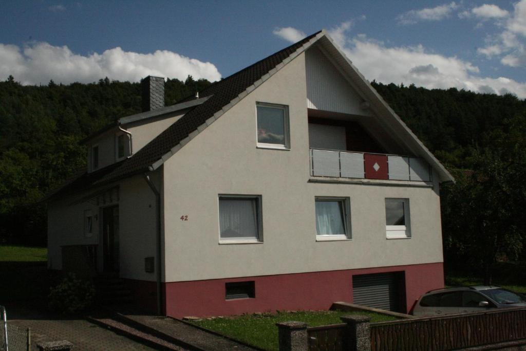 ein Haus mit einem davor geparkt in der Unterkunft Ferienwohnung Haus Rosa in Nüdlingen