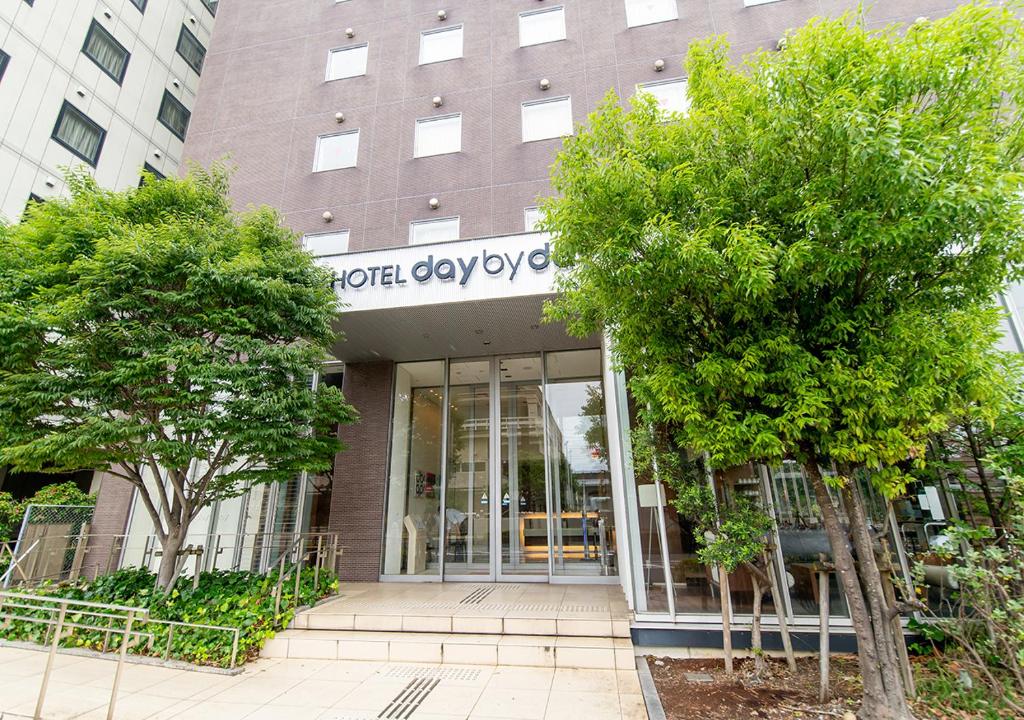 una fachada de un edificio con árboles delante de él en Hotel day by day en Hamamatsu