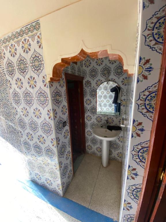 La salle de bains est pourvue d'un lavabo et d'un miroir. dans l'établissement Sahrawi Abdo, à Errachidia