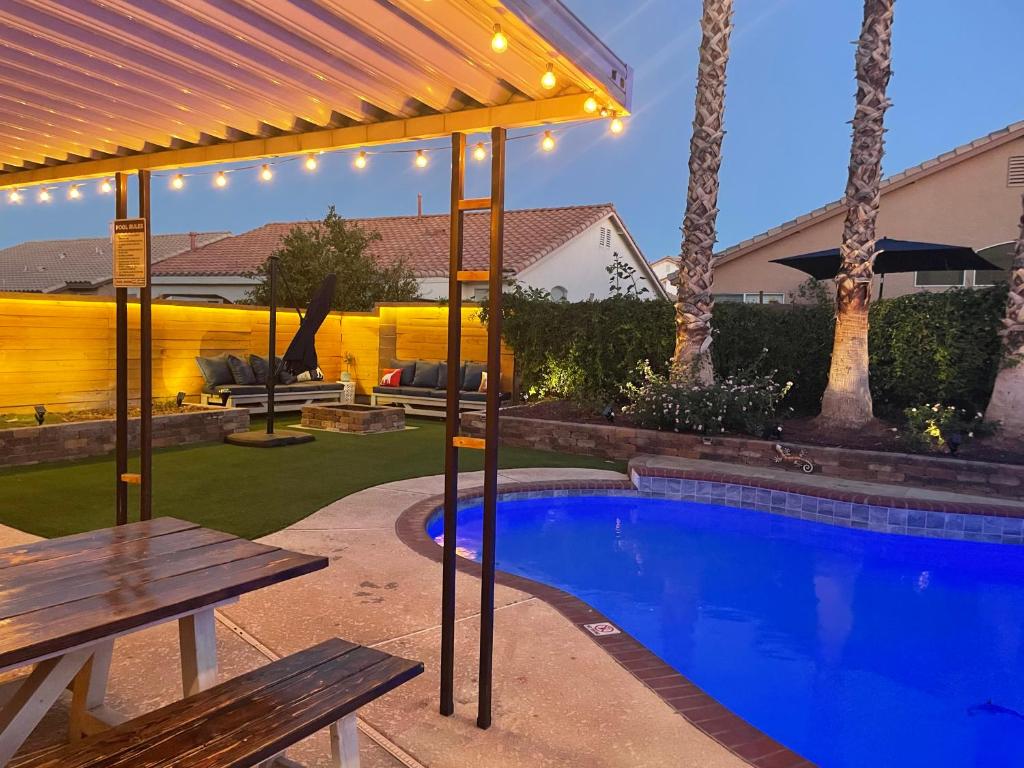 un patio trasero con piscina y mesa de picnic en Gorgeous Henderson Home with Pool! en Las Vegas