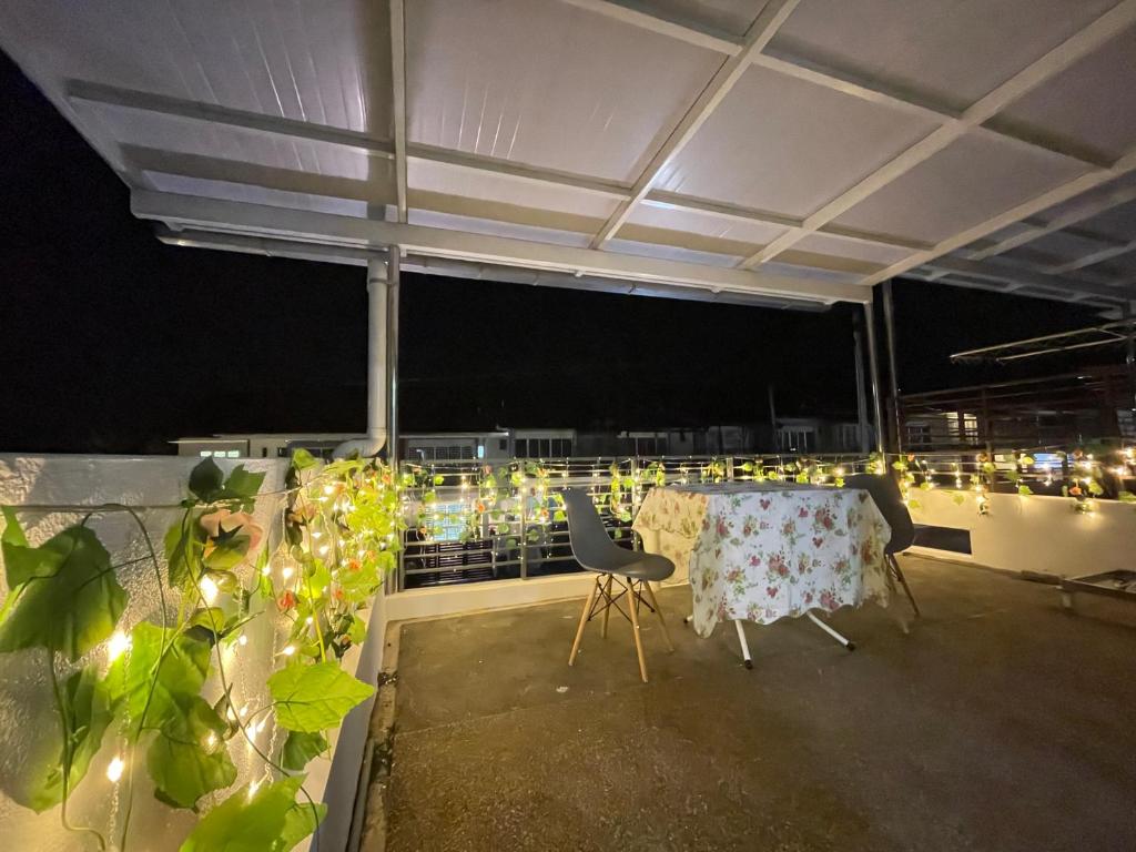 una mesa y sillas en un balcón por la noche en Homestay Balik Pulau, en Balik Pulau