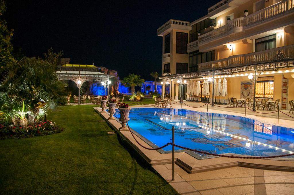 a swimming pool in front of a building at night at Kristall e Giardini dell'Eden in Ariano Irpino