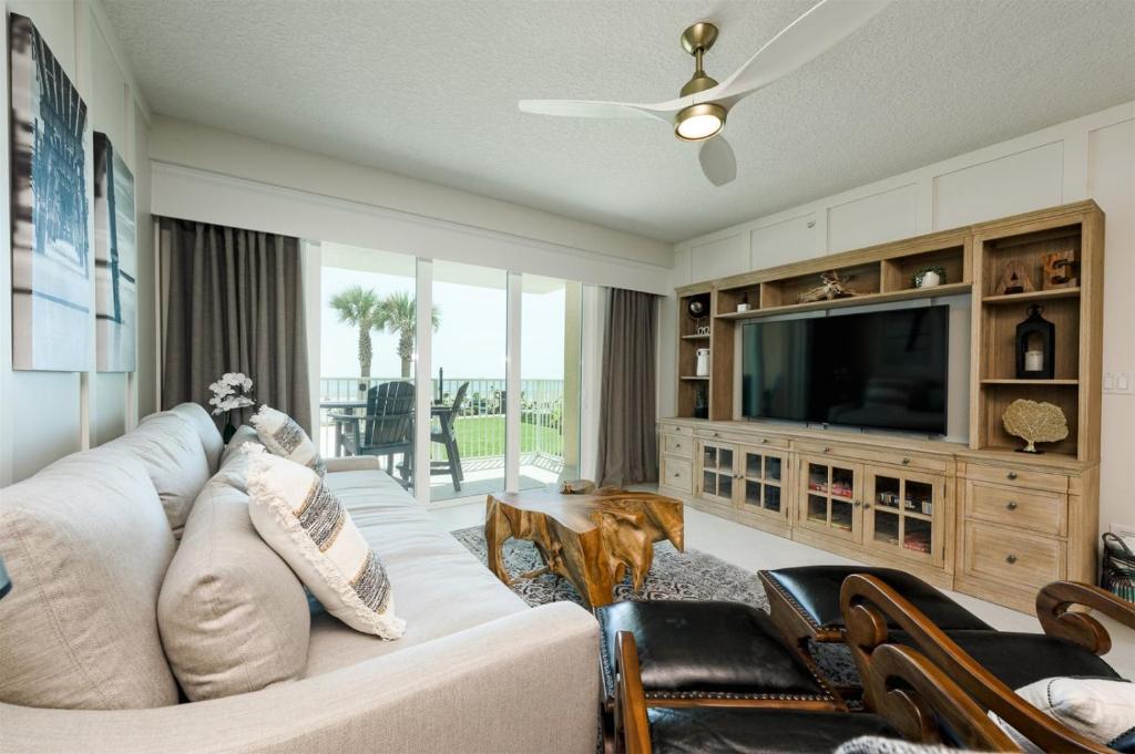 a living room with a couch and a television at Unit 103 Aruba - 3 Bedroom Ocean Front in Daytona Beach