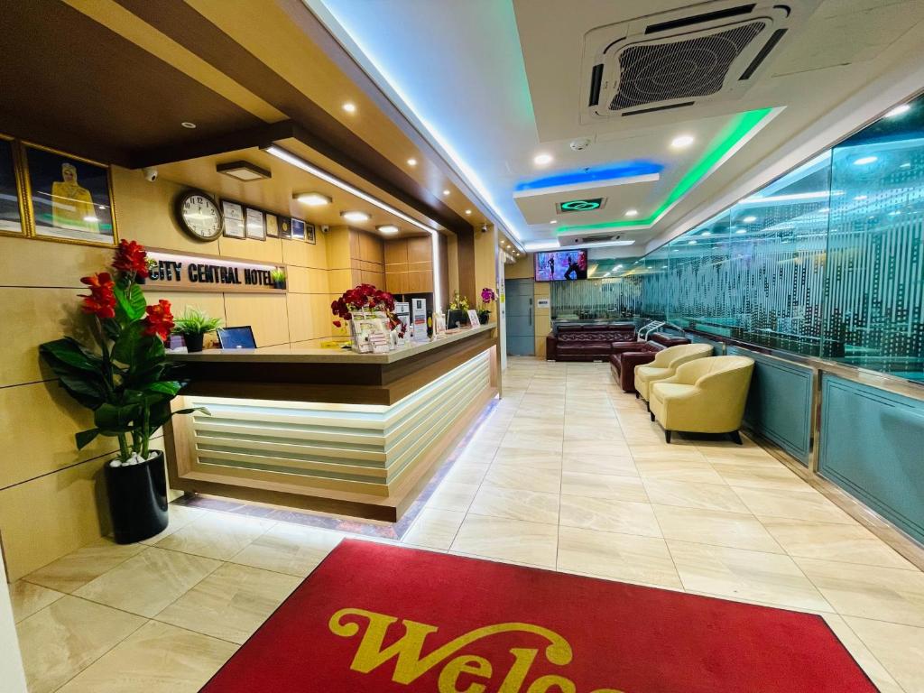 A compact reception lobby with a front desk, waiting chairs and bright decorative lighting.