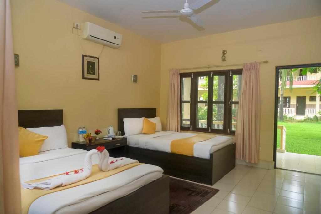 una camera da letto con due letti e una finestra di Hotel Rainforest a Sauraha