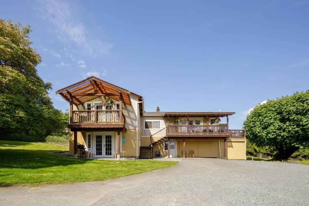 a large house with a balcony and a driveway at Gorgeous 7BDR 16 Guests Perfect For Your Family in Nanaimo