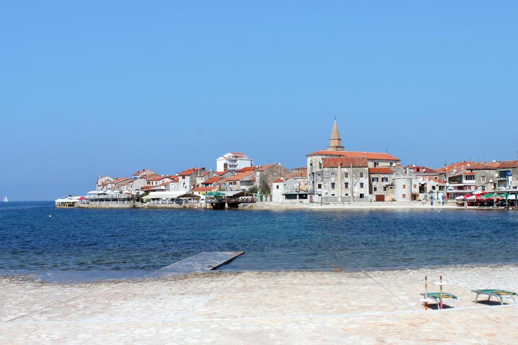 widok na plażę z budynkami i wodą w obiekcie Apartments with a parking space Umag - 16354 w mieście Umag
